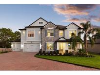 Charming two-story home with stone accents, a brick driveway, and lush landscaping, blending elegance and curb appeal at 13016 Shady Retreat Loop, Clermont, FL 34711