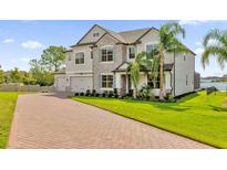 Two-story house with stone accents and a three-car garage at 13016 Shady Retreat Loop, Clermont, FL 34711