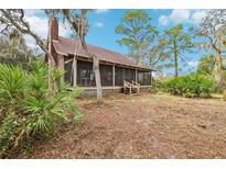 Charming screened porch, complemented by mature trees and natural surroundings at 2459 Adelia Blvd, Deltona, FL 32725