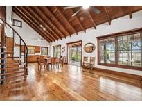 Bright living room with wood floors, spiral staircase, wood beam ceiling and open access to the outside at 2459 Adelia Blvd, Deltona, FL 32725