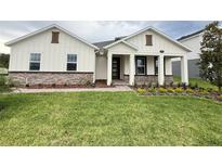 Charming single-Gathering home featuring stone accents, lush green lawn, and a welcoming front porch at 2564 Hawks Overlook Pl, Oviedo, FL 32765