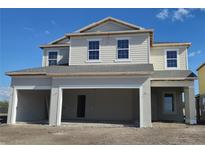 Unfinished two-story home with three car garage featuring blue skies, and an unfinished yard at 2655 Great Heron Ave, Saint Cloud, FL 34773