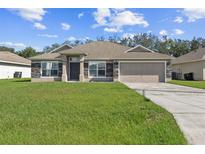 Charming single-story home featuring stone accents, attached two-car garage, and well-manicured lawn at 1928 Michigan Ct, Kissimmee, FL 34759