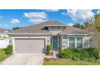 Attractive one-story house with a gray exterior, two-car garage, and landscaping at 1162 Alder Tree Dr, Apopka, FL 32703