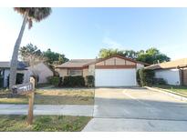 Charming single-Gathering home with a well-manicured lawn and attached two-car garage at 666 Sausalito Blvd, Casselberry, FL 32707