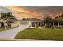 Charming single-story home with a well-manicured lawn, gray roof, and a two-car garage at 4245 Arlington Ridge Blvd, Leesburg, FL 34748