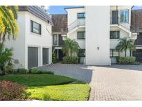 Elegant condo featuring manicured landscaping, brick driveway, and a contemporary design at 8984 Houston Pl # 103, Orlando, FL 32819