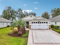 One-story home with white garage door and landscaped front yard at 2584 Dividing Creek Path, The Villages, FL 32162