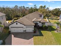 Two-story house with three car garage, paver driveway, and landscaped lawn at 2972 Crystal Water Run, Oviedo, FL 32765