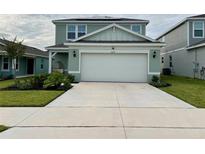 Charming two-story home with a two-car garage, manicured lawn, and well-maintained landscaping at 2227 Lovely Ln, Davenport, FL 33896