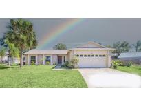 Charming single story home features a two car garage, brick accents, mature trees, and a well manicured lawn at 2204 Clementine Trl, Clermont, FL 34714