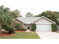Brick and shingle one-story house with a two-car garage and landscaped yard at 1003 Chesterfield Cir, Winter Springs, FL 32708