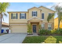 Two-story home featuring manicured landscaping and a welcoming front entrance with an attached two car garage at 1911 Betsy Ross Ln, St Cloud, FL 34769