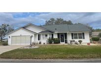 Charming single-story home with well-maintained lawn, landscaping, and a two-car garage at 5919 Mcenroe Ct, Leesburg, FL 34748