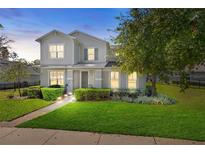 Two-story house with gray siding, manicured lawn, and walkway at 1404 High Springs Ln, Winter Garden, FL 34787