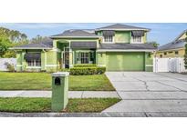 Well maintained green two story home with landscaped front yard and matching green driveway at 3136 Heartleaf Pl, Winter Park, FL 32792