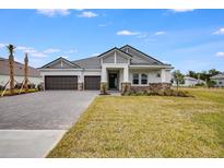 Two-story house with gray siding, stone accents, and a two-car garage at 1325 Arklow Cir, Ormond Beach, FL 32174