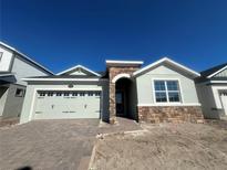 Charming single-Gathering home with stone accents, paved driveway, and a two-car garage at 5286 Teirgarten St, Saint Cloud, FL 34771