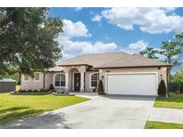 Charming single-story home with a well-manicured lawn and a two-car garage at 19808 Seaview St, Orlando, FL 32833