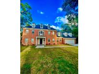 Stunning two-story brick home with a manicured lawn and attached two car garage at 211 River Bluff Dr, Ormond Beach, FL 32174