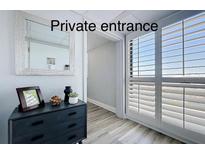 Elegant entryway with a modern dresser, stylish mirror, and bright natural light from shuttered doors at 6165 Carrier Dr # 2602, Orlando, FL 32819