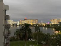 Beautiful nighttime view of the resort and lake area with twinkling lights creating a magical ambiance at 6165 Carrier Dr # 2602, Orlando, FL 32819