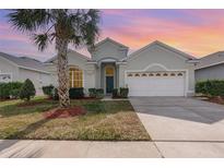 One-story house with a two-car garage, palm trees, and well-manicured lawn at 8169 Fan Palm Way, Kissimmee, FL 34747