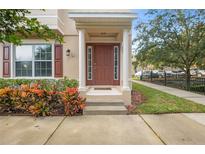 Inviting house entrance with brown door, columns, and landscaping at 207 Maplebrook Dr, Altamonte Springs, FL 32714