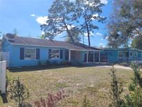 Charming single-story home featuring a light blue exterior and a spacious front yard at 5018 Figwood Ln, Orlando, FL 32808