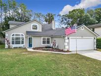 Charming two-story home with a well-manicured lawn and an American flag waving in the breeze at 5240 N Lake Burkett Ln, Winter Park, FL 32792