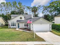Charming two-story home with a well-manicured lawn and an attached two-car garage at 5240 N Lake Burkett Ln, Winter Park, FL 32792