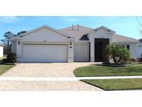 Charming single-story home featuring a well-manicured lawn and a brick-paved driveway leading to a spacious three-car garage at 3621 Arlington Ridge Blvd, Leesburg, FL 34748