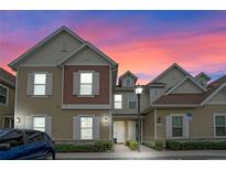 Two-story townhome with light beige and brown siding, and a walkway at 7540 Sunville Ave, Kissimmee, FL 34747