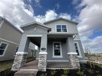 Beautiful two-story home with a covered porch, brick accents, and manicured landscaping at 1342 Twelve Oaks Rd, Saint Cloud, FL 34771