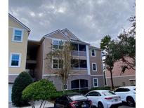 Three-story exterior view of condo with screened lanai at 3468 Soho St # 107, Orlando, FL 32835