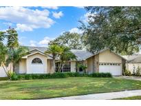 One-story house with brick facade, mature landscaping, and a two-car garage at 1007 Tony Cir, St Cloud, FL 34772