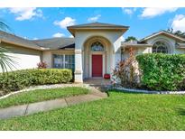 House exterior featuring a red door, landscaping, and walkway at 103 Old Sunbeam Dr, South Daytona, FL 32119