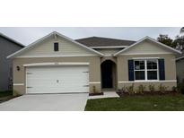 Charming single-story home featuring a two-car garage, dark shutters, and a well-maintained lawn at 3450 Islewood Ct, Ocoee, FL 34761