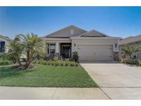 Charming single-story home featuring a well-manicured lawn and a two-car garage at 7889 Penrose Pl, Wildwood, FL 34785