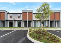 Modern townhome exterior showcases contemporary design with wood accents, gray tones, and well-maintained landscaping at 3245 Sustainable Way, Kissimmee, FL 34747