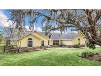 Charming yellow home with stone accents and lush lawn at 4750 Rummell Rd, St Cloud, FL 34771