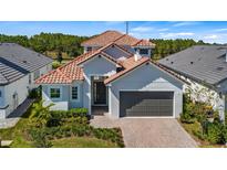 Charming two-story home with a beautiful tile roof, manicured landscaping, and a two-car garage at 212 Hampton Loop, Davenport, FL 33837