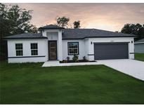 Charming one-story home featuring a modern design, a gray roof, and a well-manicured lawn at 16050 Sw 21St Ct, Ocala, FL 34473