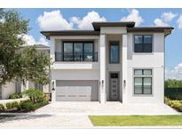 Modern two-story home with a balcony, two-car garage, and well-manicured landscaping at 1026 Jack Nicklaus Ct, Kissimmee, FL 34747