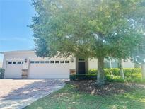 Charming single-story home with a well-manicured lawn and a brick-paved driveway leading to a two-car garage at 2871 Sandy Cay St, Clermont, FL 34711