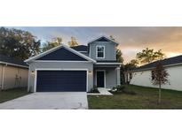 Charming two-story home with a navy blue garage door and a well-manicured lawn at 174 14Th Avenue, Longwood, FL 32750