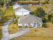 Aerial view of a house with detached garage and pond at 3330 La Salle Ave, Saint Cloud, FL 34772