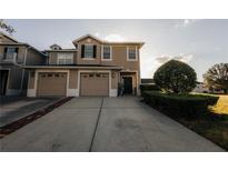 Inviting two-story home featuring a two-car garage, manicured landscaping, and a neatly paved driveway at 13910 Dove Wing Ct, Orlando, FL 32828