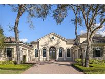 Stunning home with arched entryway, brick driveway, tile roof, and lush landscaping at 8681 Crested Eagle Pl, Sanford, FL 32771
