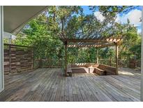 Spacious wooden deck with pergola and built-in seating, perfect for outdoor relaxation and entertaining at 2801 Ripton Ct, Orlando, FL 32835